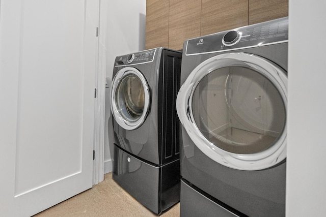 laundry area featuring washer and dryer, laundry area, and light carpet