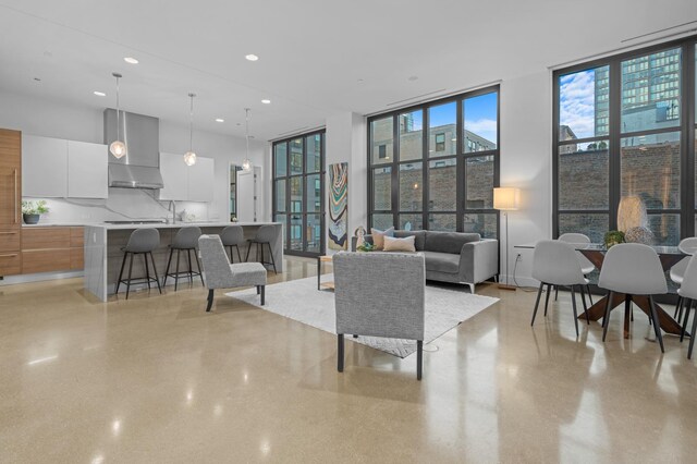 living room featuring recessed lighting, plenty of natural light, and floor to ceiling windows