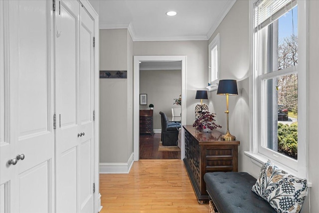 hall with light wood finished floors, baseboards, recessed lighting, and ornamental molding