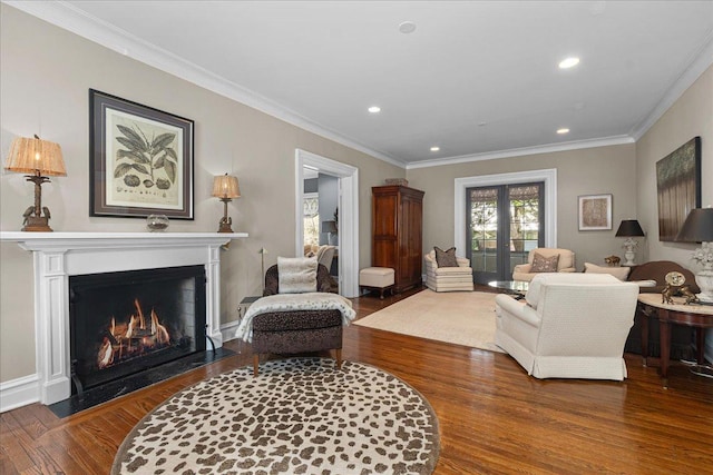 living area with a fireplace with flush hearth, wood finished floors, ornamental molding, and recessed lighting