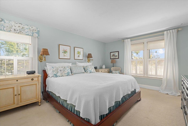 bedroom with light colored carpet and baseboards