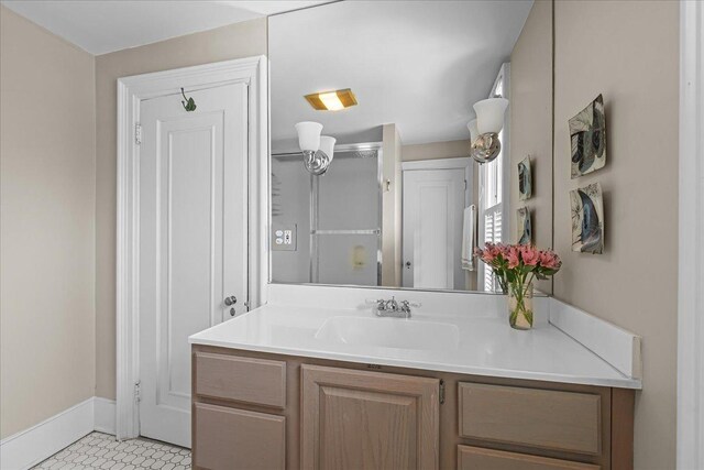 bathroom with baseboards, tile patterned flooring, vanity, and a shower with door