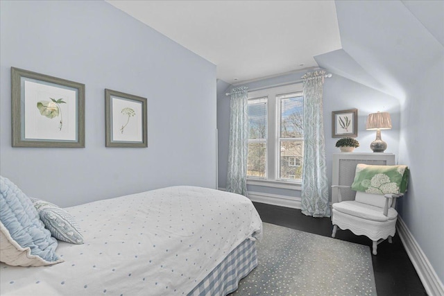 bedroom featuring vaulted ceiling, baseboards, and wood finished floors