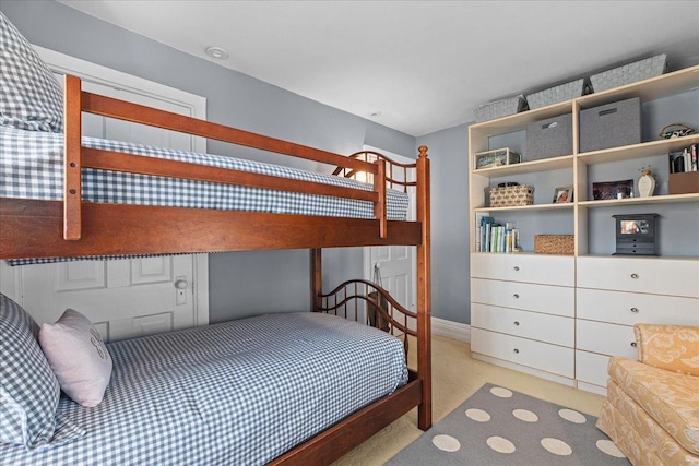 bedroom featuring light carpet and baseboards