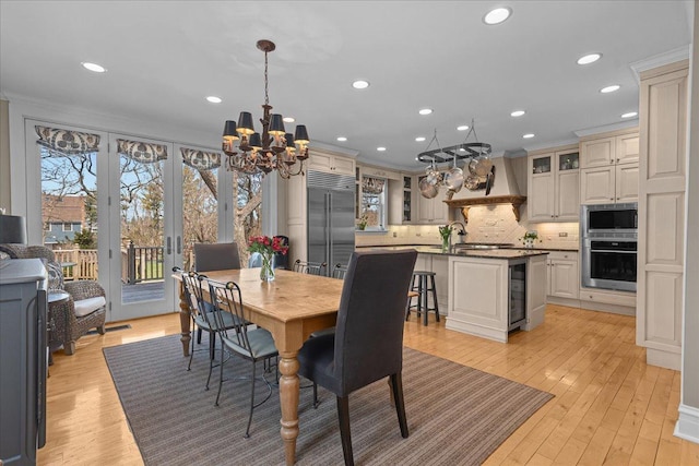 dining space with recessed lighting, wine cooler, a wealth of natural light, and a chandelier