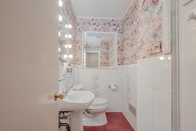 bathroom featuring a sink, toilet, visible vents, wallpapered walls, and tile patterned flooring