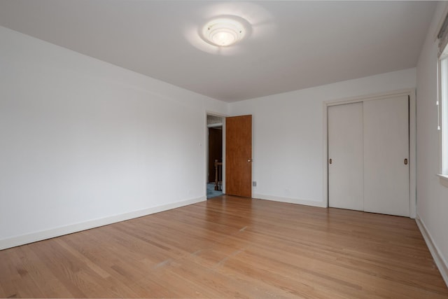 empty room featuring light wood-type flooring and baseboards