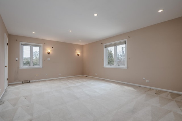 empty room with light colored carpet, baseboards, and recessed lighting