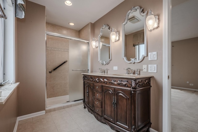 bathroom featuring a tile shower, double vanity, baseboards, and a sink