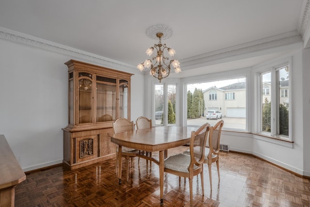 dining room featuring a chandelier, baseboards, and ornamental molding