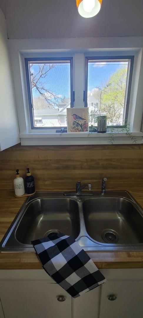 interior details with white cabinetry and a sink