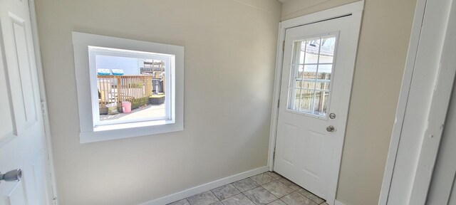 doorway with baseboards and a healthy amount of sunlight