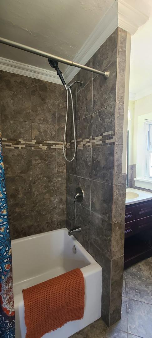 full bath featuring shower / tub combo, vanity, and ornamental molding