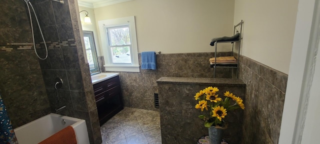 bathroom with visible vents, tile walls, crown molding, vanity, and a wainscoted wall