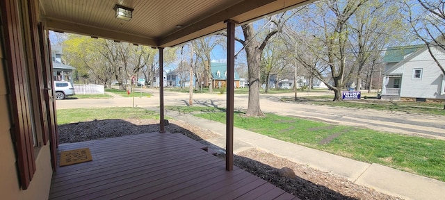 wooden terrace featuring a residential view and a lawn