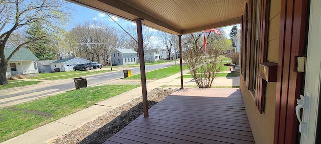 wooden deck featuring a residential view and a lawn