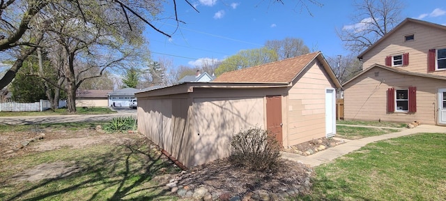 view of outbuilding featuring fence and an outdoor structure