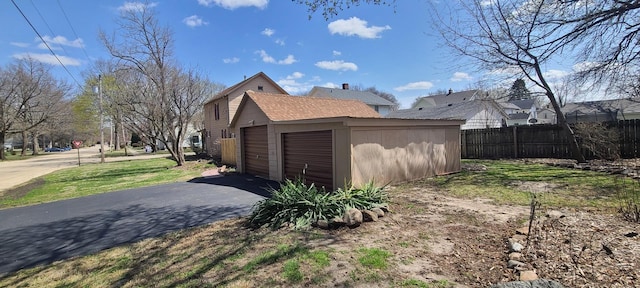 view of side of home with fence and a garage
