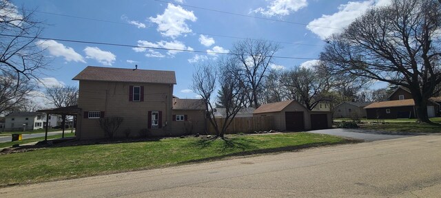 view of front of house with an outbuilding, a residential view, a front lawn, and a detached garage