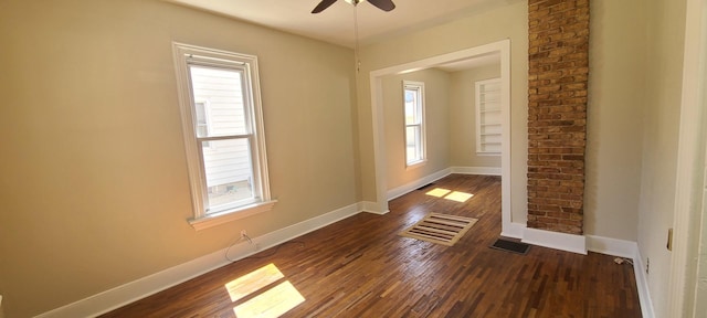 spare room featuring visible vents, dark wood-style flooring, baseboards, and ceiling fan