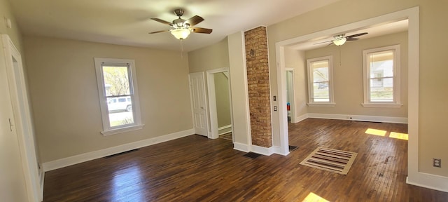 unfurnished bedroom with dark wood-style flooring, multiple windows, and visible vents