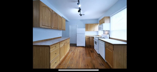 kitchen featuring light brown cabinets, wood finished floors, white appliances, and light countertops