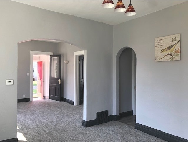 1639 Victoria Ave, North Chicago, IL 60064 - spare room with dark carpet, baseboards, and arched walkways