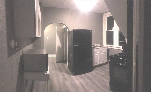 1639 Victoria Ave, North Chicago, IL 60064 - kitchen featuring white cabinetry, light wood-type flooring, and a sink