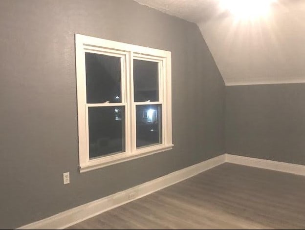 1639 Victoria Ave, North Chicago, IL 60064 - additional living space featuring baseboards, vaulted ceiling, and wood finished floors