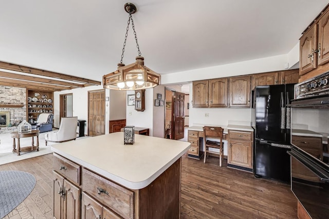 kitchen featuring dark wood-style flooring, light countertops, a center island, open floor plan, and black appliances
