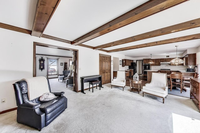 living room with beamed ceiling, baseboards, a chandelier, and light carpet