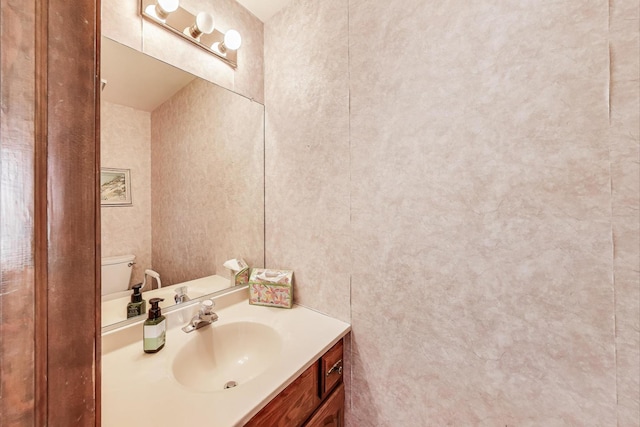 half bath featuring vanity and toilet