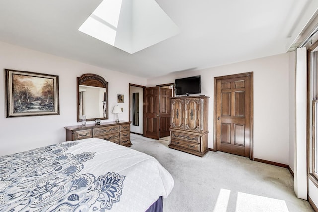 bedroom with light colored carpet, baseboards, and a skylight