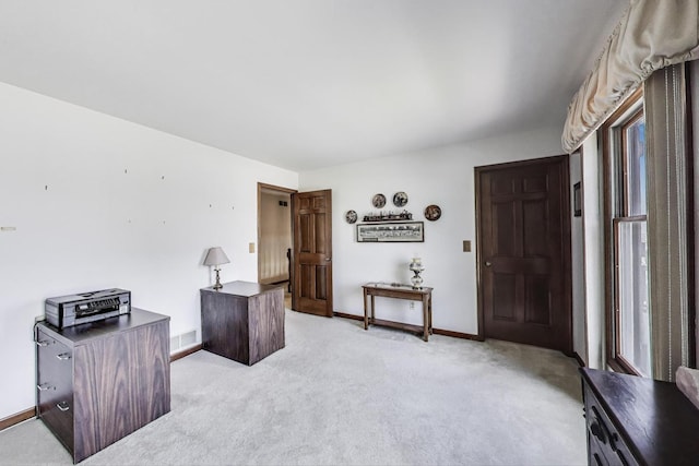 office area with light colored carpet, baseboards, plenty of natural light, and visible vents