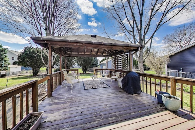 deck featuring fence, an outdoor structure, a gazebo, and a lawn