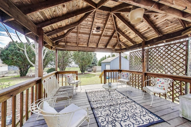 wooden terrace with fence, an outdoor structure, a yard, and a shed