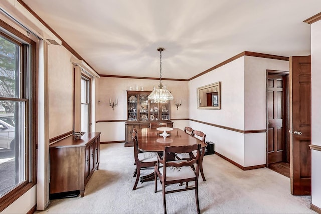 dining area with baseboards, a notable chandelier, a healthy amount of sunlight, and light carpet