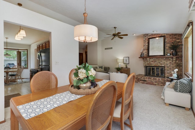 608 Cheshire Dr, Bloomington, IL 61704 - dining room with a brick fireplace, a ceiling fan, and light colored carpet