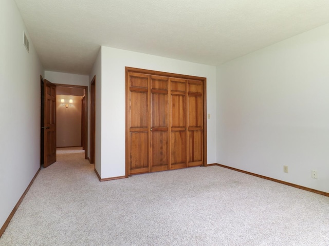 608 Cheshire Dr, Bloomington, IL 61704 - unfurnished bedroom featuring carpet flooring, baseboards, and a closet