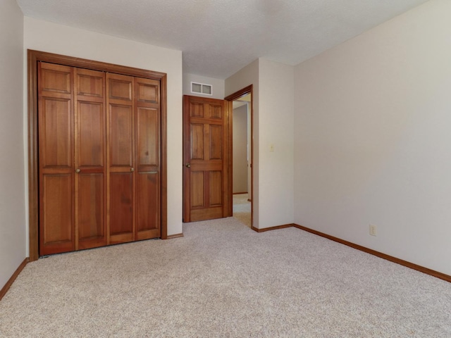 608 Cheshire Dr, Bloomington, IL 61704 - unfurnished bedroom with carpet floors, baseboards, and a closet