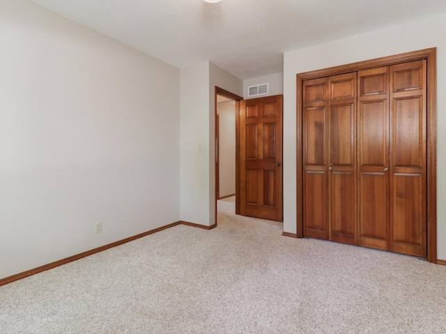 608 Cheshire Dr, Bloomington, IL 61704 - unfurnished bedroom featuring light carpet, baseboards, and a closet