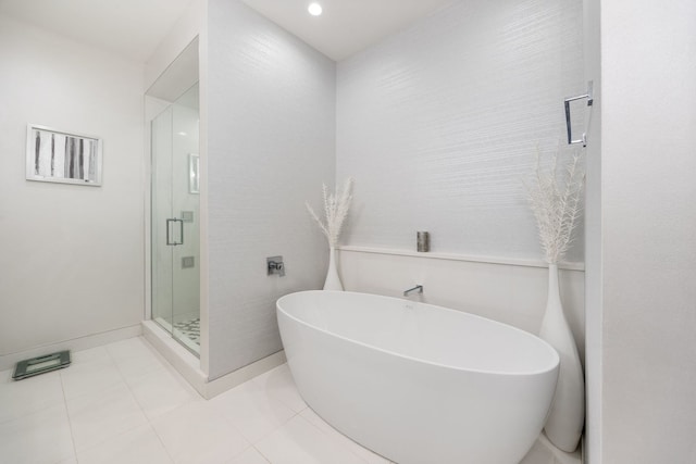 full bath featuring tile patterned flooring, a freestanding bath, and a stall shower