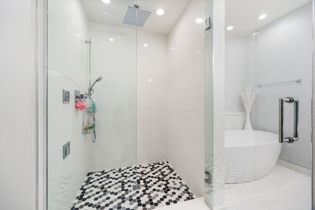full bathroom featuring a shower stall, a freestanding bath, tile patterned floors, and recessed lighting