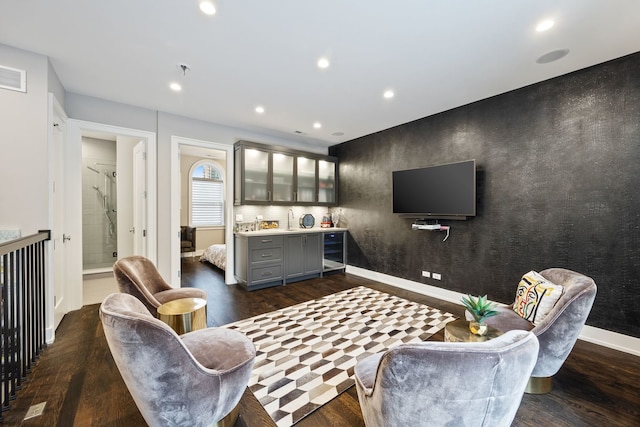 living room featuring bar area, baseboards, recessed lighting, and dark wood-style flooring