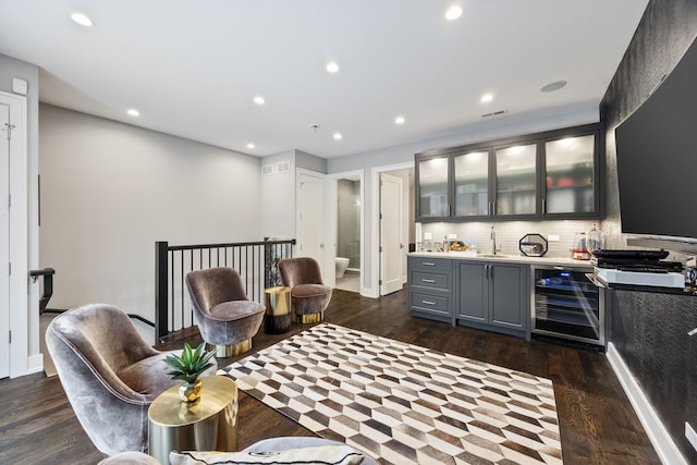 bar with tasteful backsplash, indoor wet bar, a sink, wine cooler, and dark wood-type flooring
