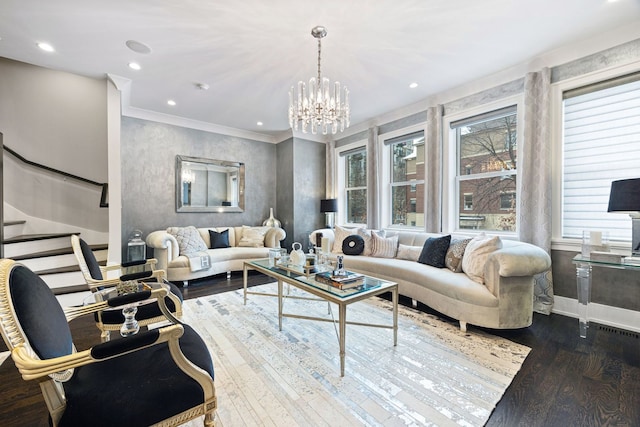 living area with crown molding, wood finished floors, an inviting chandelier, and a wealth of natural light