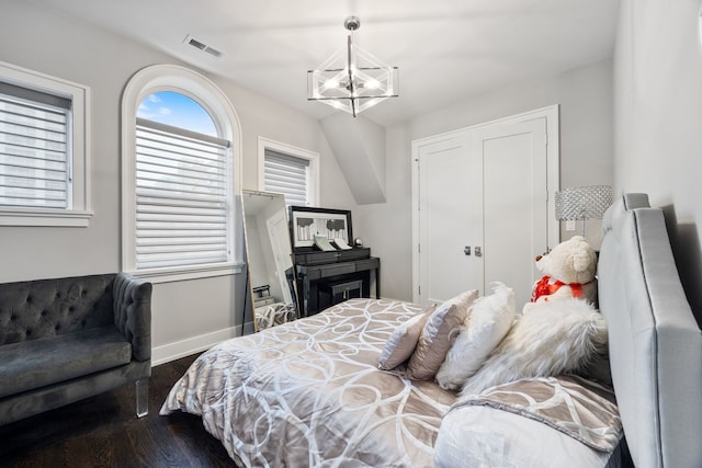 bedroom featuring visible vents, baseboards, a chandelier, and wood finished floors