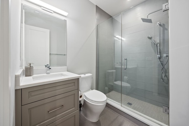 bathroom featuring toilet, a stall shower, and vanity