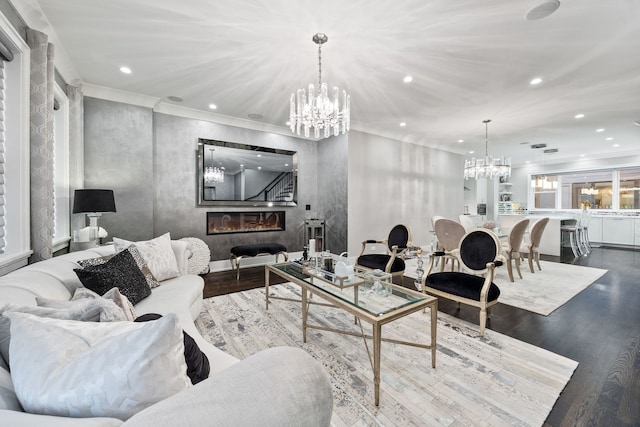 living room with crown molding, an inviting chandelier, recessed lighting, wood finished floors, and stairs