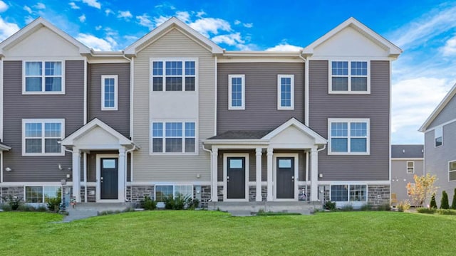 view of front of home with a front yard and stone siding